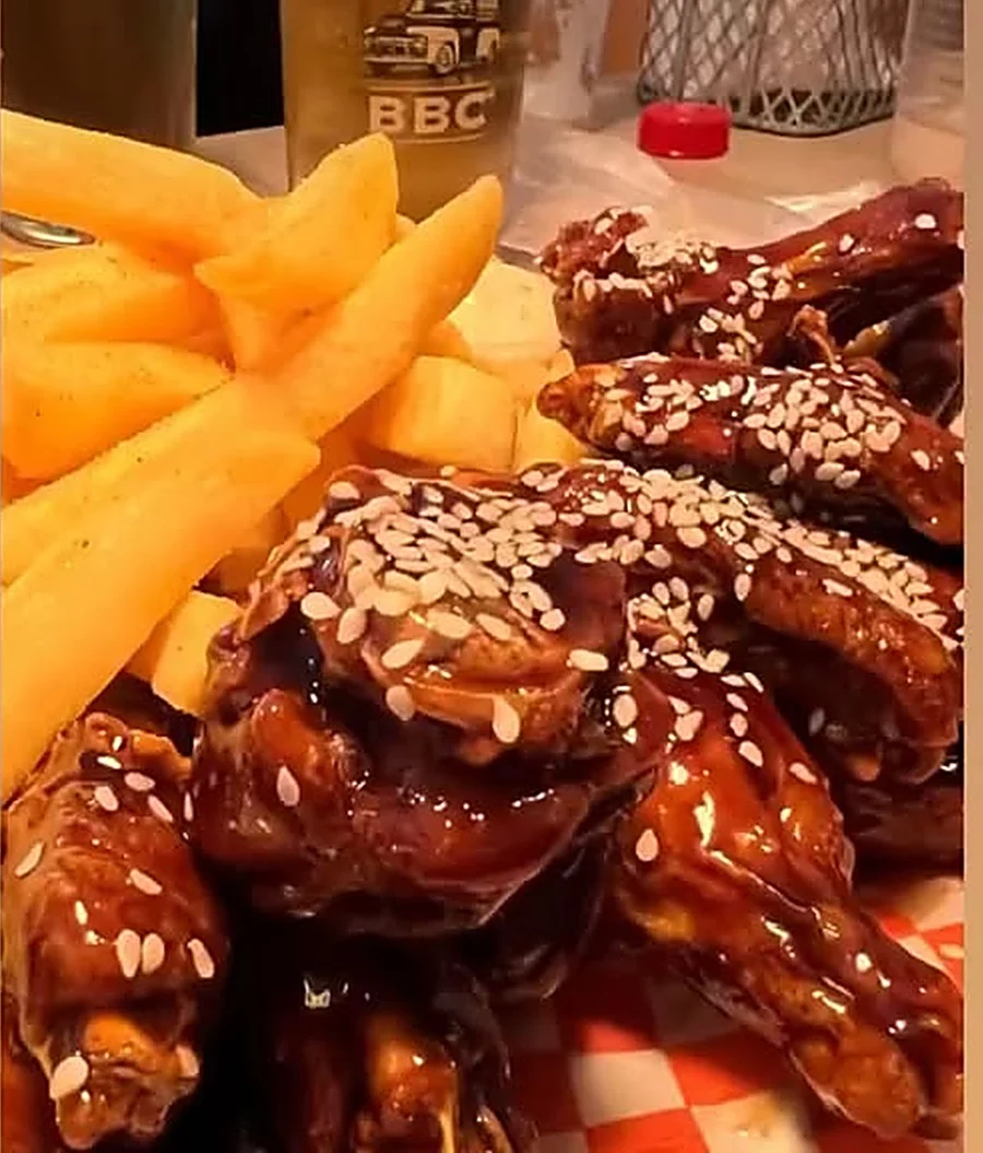 Alitas reales de Billy Wings con sésamo, papas a la francesa y una cerveza BBC